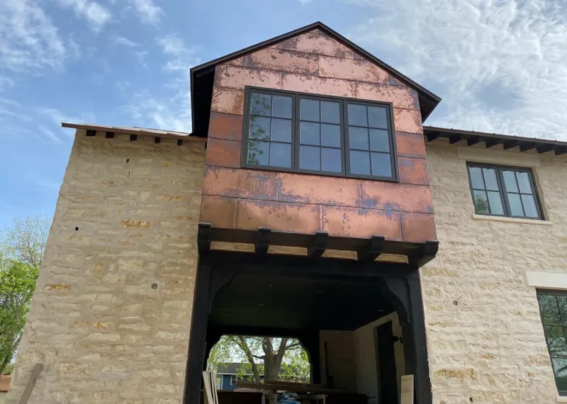 Copper metal panel facade on a stone building for Roof Repair in Forks